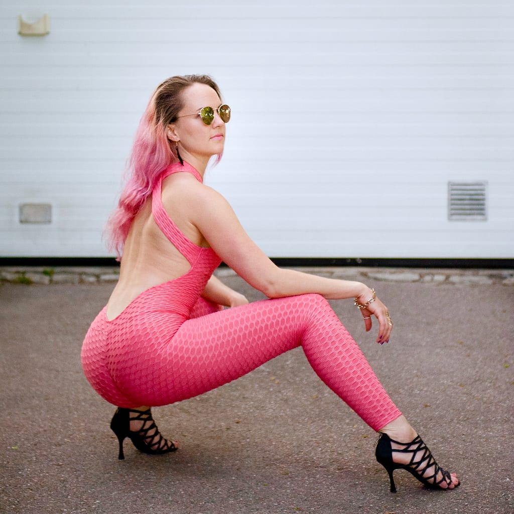 Outdoor dance pose in a pink outfit and dance shoes.